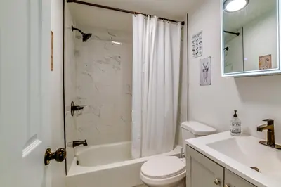 a white bathroom with a shower and a toilet and a sink at Nature Escape in Unadilla Modern Home with 2 Decks in Unadilla