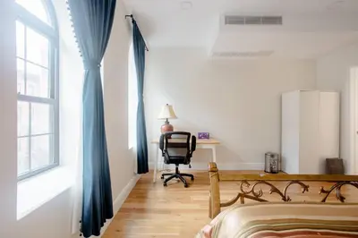 a bedroom with blue curtains and a desk and a chair at Little manhattan near Time Square in New York