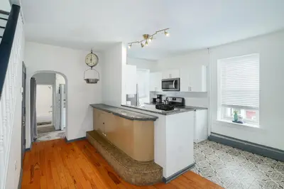 a kitchen with white cabinets and a counter top at Large Bi-level Apartment in Heart of Manayunk in Bala-Cynwyd