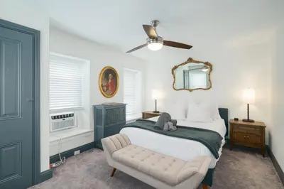 a bedroom with a bed and a chair and a ceiling fan at Large Bi-level Apartment in Heart of Manayunk in Bala-Cynwyd