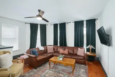 a living room with a couch and a tv at Large Bi-level Apartment in Heart of Manayunk in Bala-Cynwyd