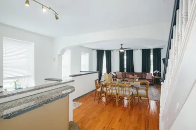 a dining room and living room with a table and chairs at Large Bi-level Apartment in Heart of Manayunk in Bala-Cynwyd