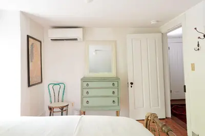 a bedroom with a green dresser and a chair at Ulster County Farmhouse Near Waterfalls and Winery! in Pine Bush