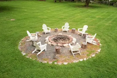 a fire pit with white chairs and tables in a yard at Ulster County Farmhouse Near Waterfalls and Winery! in Pine Bush