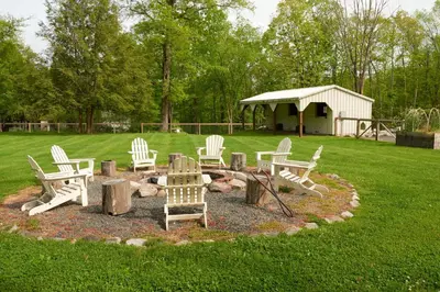 a group of chairs and a fire pit in a yard at Ulster County Farmhouse Near Waterfalls and Winery! in Pine Bush