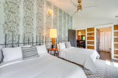two beds in a room with wallpaper at Grill and Fire Pit Eclectic Ulster County Cabin in Pine Bush