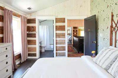 a bedroom with a bed and a bathroom at Grill and Fire Pit Eclectic Ulster County Cabin in Pine Bush