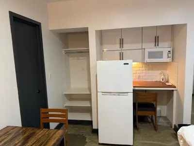 a kitchen with a white refrigerator and a table at Tribeca Hotel FiDi in New York