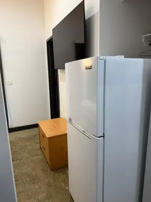 a kitchen with a white refrigerator and a wooden box at Tribeca Hotel FiDi in New York