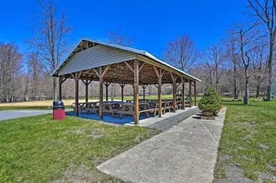 a picnic pavilion with benches in a park at Wooded Tobyhanna Home with Fire Pit and Lake Access! in Tobyhanna