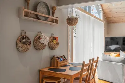 a dining room with a table and baskets on the wall at Pocono Scandinavian Cottage cottage in Tobyhanna