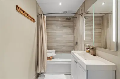 a bathroom with a white tub and a sink and a bath tub at Pocono Scandinavian Cottage cottage in Tobyhanna