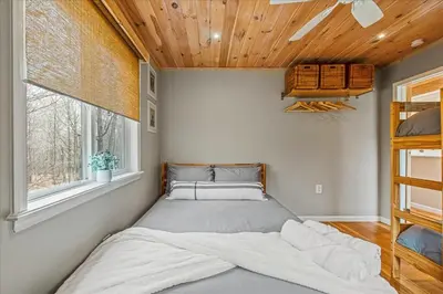 a bed in a bedroom with a wooden ceiling at Pocono Scandinavian Cottage cottage in Tobyhanna