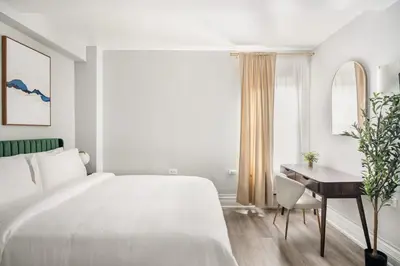 a white bedroom with a bed and a desk at 73-310 Newly Reno Studio UWS Doorman Gym Laundry in New York