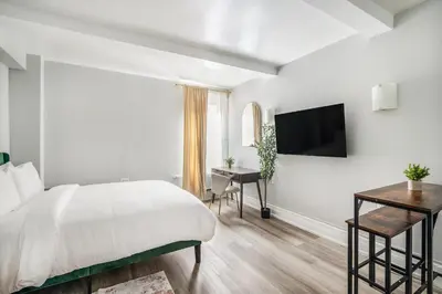 a white bedroom with a bed and a desk at 73-310 Newly Reno Studio UWS Doorman Gym Laundry in New York