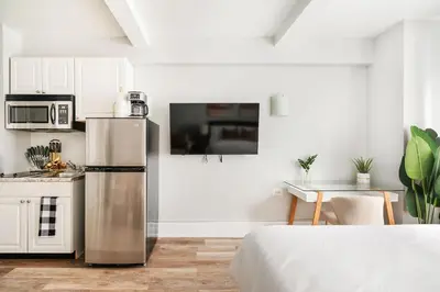 a kitchen with a stainless steel refrigerator in a room at 73-304 Newly Reno Studio UWS Doorman Gym Laundry in New York