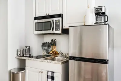 a kitchen with a stainless steel refrigerator and microwave at 73-304 Newly Reno Studio UWS Doorman Gym Laundry in New York
