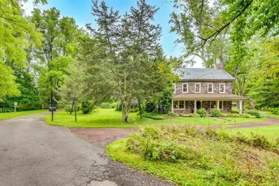 an empty road leading to a house at Steps to Delaware Canal Enchanting Stone Cottage! in Kintnersville