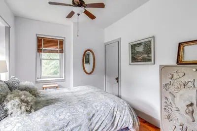 a bedroom with a bed and a ceiling fan at Steps to Delaware Canal Enchanting Stone Cottage! in Kintnersville