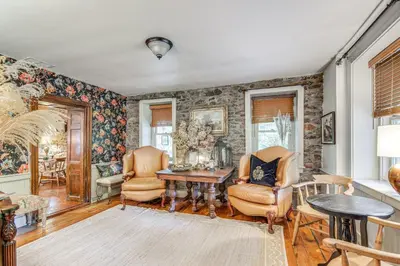 a living room with a table and chairs at Steps to Delaware Canal Enchanting Stone Cottage! in Kintnersville