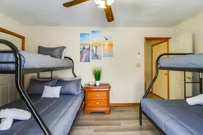 a room with two bunk beds and a table at Private Hot Tub Lakefront Poconos Home! in Pocono Summit