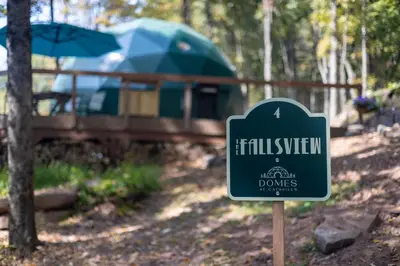 a sign in front of a tent in the woods at Domes at Catskills in Swan Lake