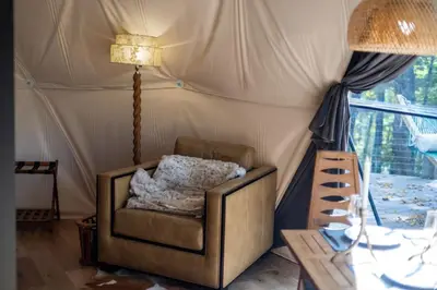 a room with a chair and a lamp in a tent at Domes at Catskills in Swan Lake