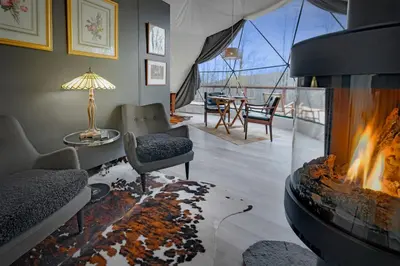 a living room with a fireplace and a table at Domes at Catskills in Swan Lake