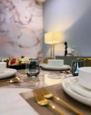 a table with plates and forks and glasses on it at Spacious & Stylish 2BR 2BA - Easy NYC Commute in Jersey City