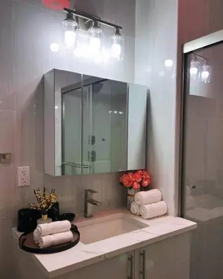 a bathroom with a sink with a mirror and towels at Spacious & Stylish 2BR 2BA - Easy NYC Commute in Jersey City