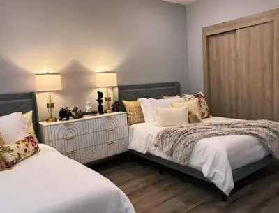 a bedroom with two beds and a dresser with two lamps at Spacious & Stylish 2BR 2BA - Easy NYC Commute in Jersey City