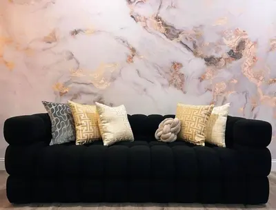 a black couch with pillows in front of a marble wall at Spacious & Stylish 2BR 2BA - Easy NYC Commute in Jersey City
