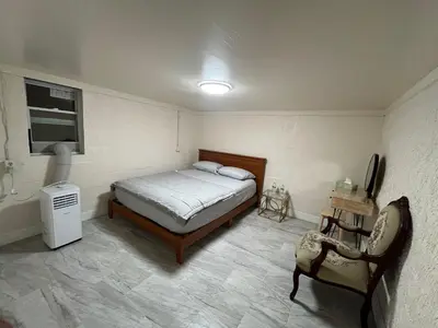 a small bedroom with a bed and a chair at The Serene Retreat in Metuchen
