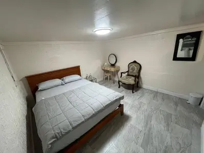a bedroom with a bed and a chair and a table at The Serene Retreat in Metuchen