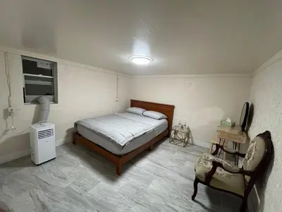 a bedroom with a bed and a television and a chair at The Serene Retreat in Metuchen