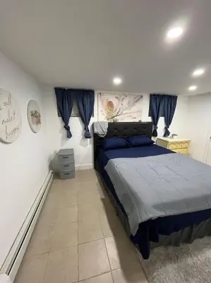 a bedroom with a bed in a white room at 2 Bedroom Apartment By AirportS in Hillside