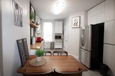 a kitchen and dining room with a table and a refrigerator at Hoboken 15 Min Train to Manhattan Full Kitchen in Hoboken