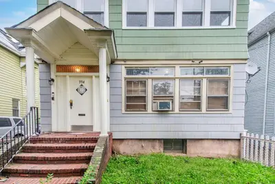 a house with a white door and stairs in front at Perfect Private Unit in Passaic in Passaic