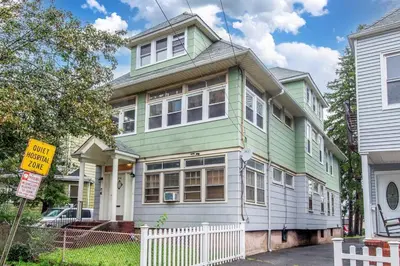 a green and white house with a white fence at Perfect Private Unit in Passaic in Passaic