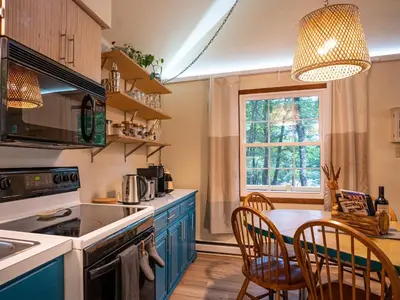 a kitchen with blue cabinets and a table with chairs at That Gray House Romantic getaway in Albrightsville