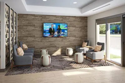 a living room with a tv on a brick wall at Candlewood Suites Lawrenceville - Princeton by IHG in Lawrenceville