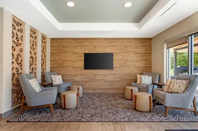 a waiting room with chairs and a flat screen tv at Candlewood Suites Lawrenceville - Princeton by IHG in Lawrenceville