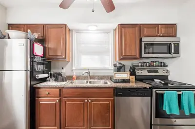 a kitchen with wooden cabinets and a stainless steel refrigerator at The Beautiful & Cozy Malvec Chalet in Tobyhanna