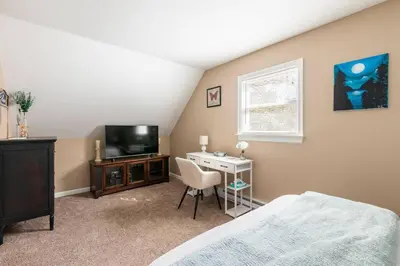 a bedroom with a bed and a desk and a television at The Beautiful & Cozy Malvec Chalet in Tobyhanna
