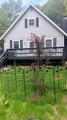 a white house with a fence in front of it at The Beautiful & Cozy Malvec Chalet in Tobyhanna