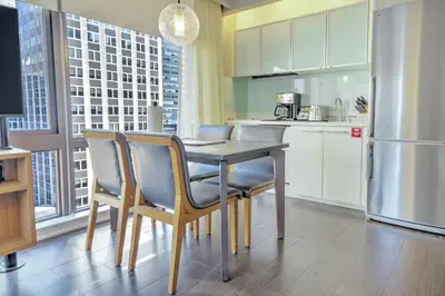 a kitchen with a table and chairs and a refrigerator at Beautiful Resort in Midtown 45 - Deluxe 1BD in New York