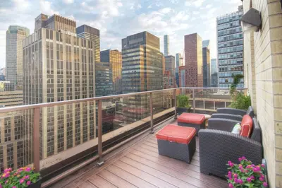 a balcony with chairs and a view of a city at Beautiful Resort in Midtown 45 - Deluxe 1BD in New York