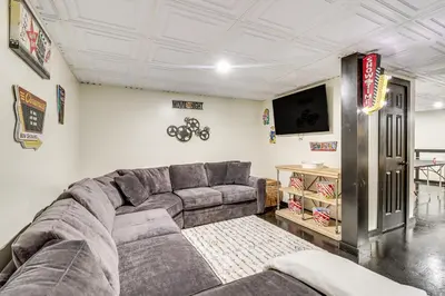 a living room with a couch and a flat screen tv at 7 Mi to Big Boulder Resort-Style Poconos Retreat in Albrightsville