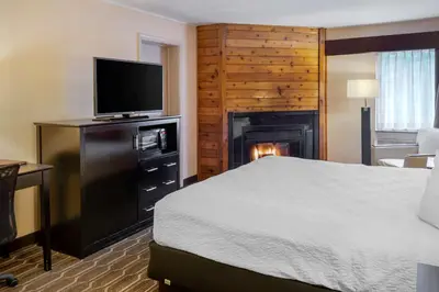 a hotel room with a bed and a fireplace at BEST WESTERN PLUS Poconos in Tannersville