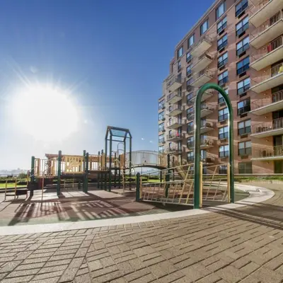 an empty playground in front of a building at Global Luxury Suites at Hoboken Waterfront in Hoboken